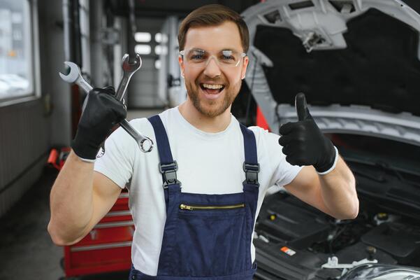 portrait shot of a handsome mechanic working on a vehicle in a car service modern clean workshop photo